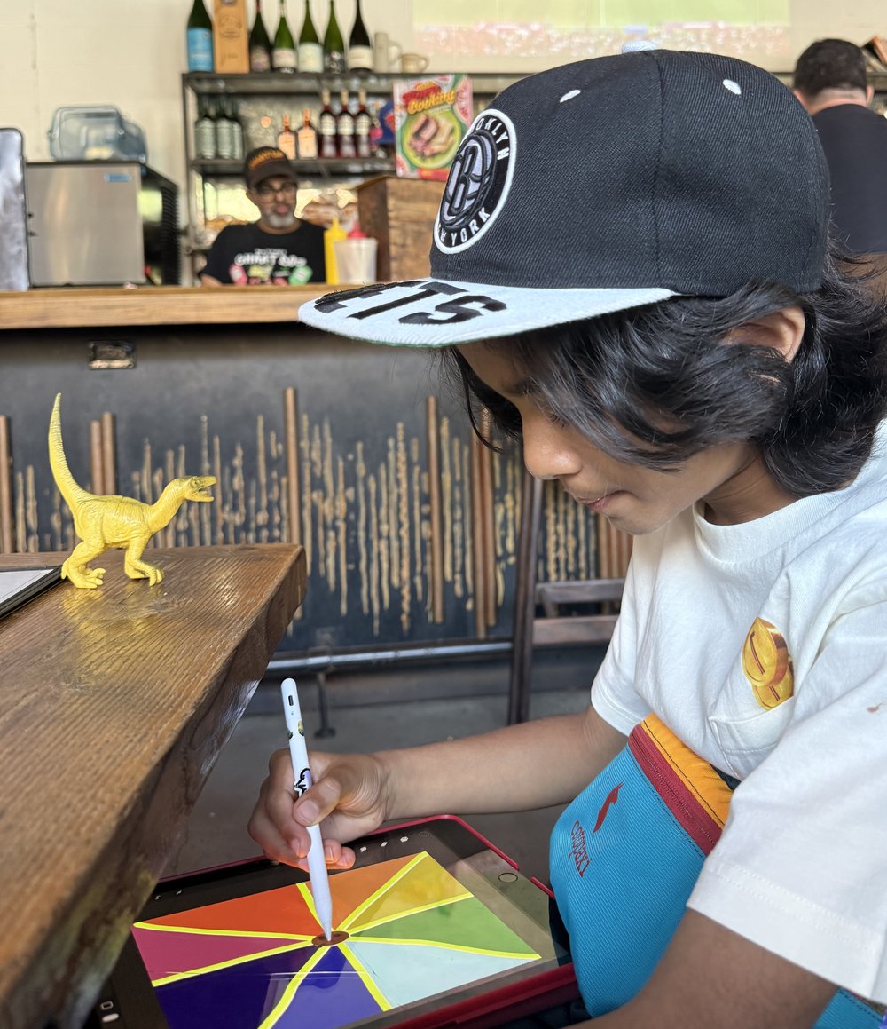 Kavi drawing on his iPad at a workshop